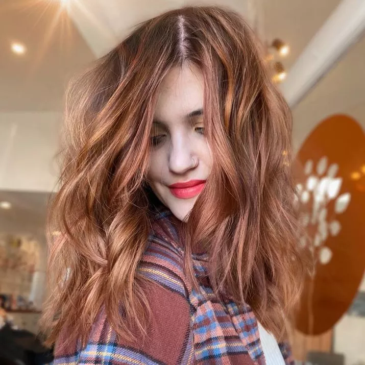 Woman with peachy strawberry brown hair color