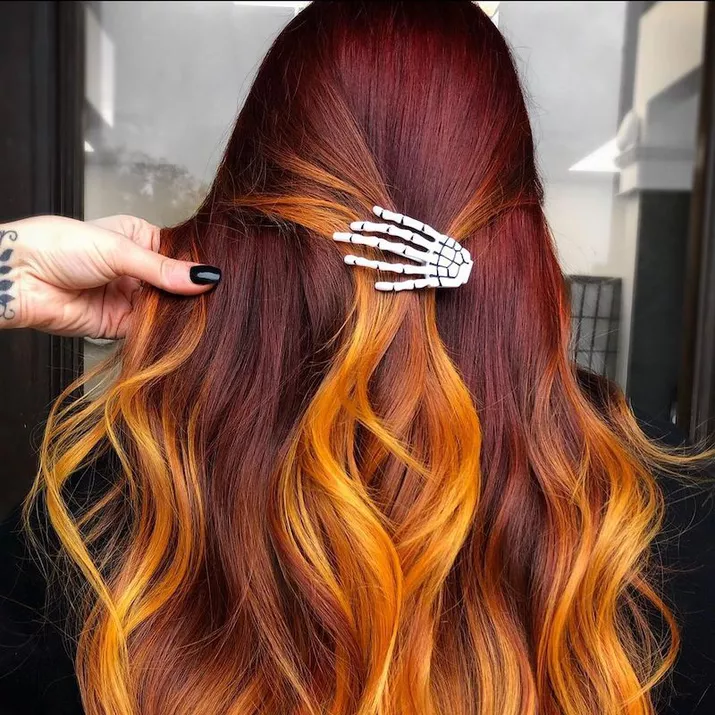 Orange ombre hair with skeleton hand clip viewed from back