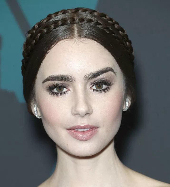 Lilly Collins with a sleek braided crown hairstyle