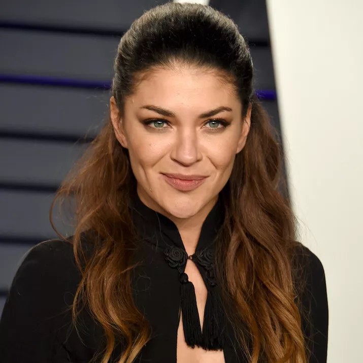 Jessica Szohr wears a long, wavy half-up hairstyle