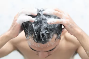 man scrubbing his scalp with shampoo
