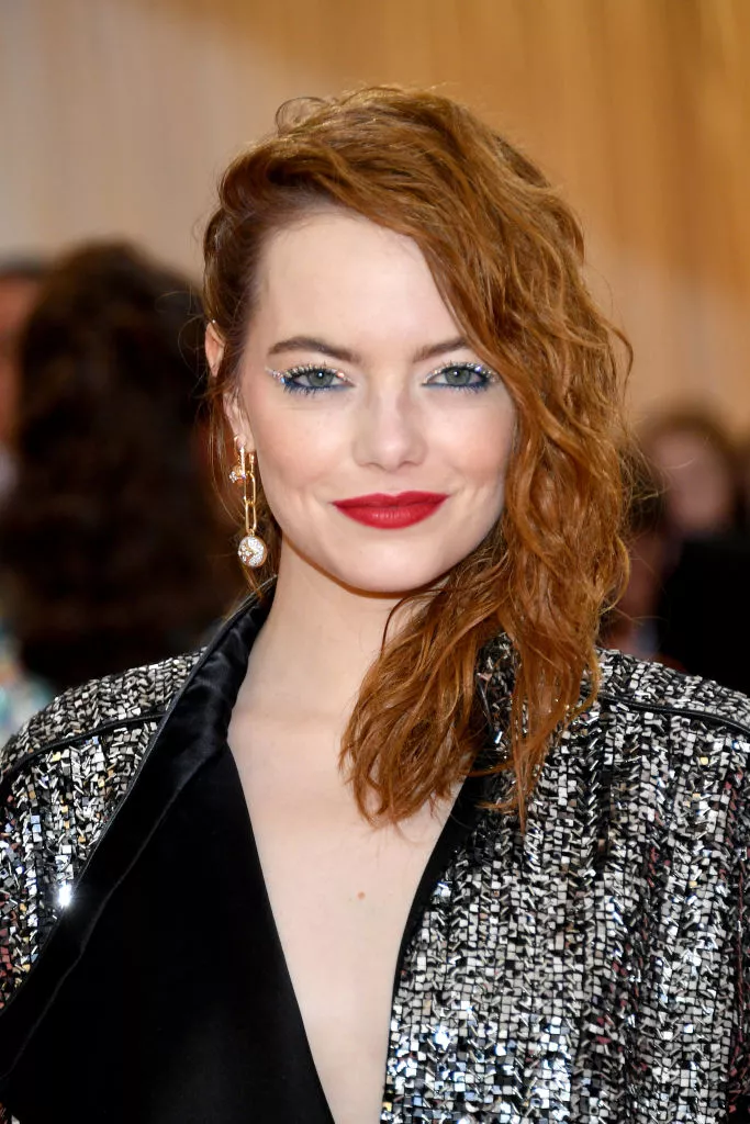 Emma Stone deep side-parted wavy, wet mid-length hair