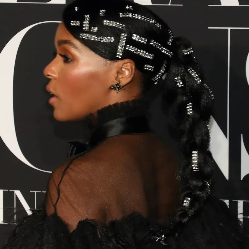 Janelle Monae wears a ponytail braid with many bedazzled barrettes