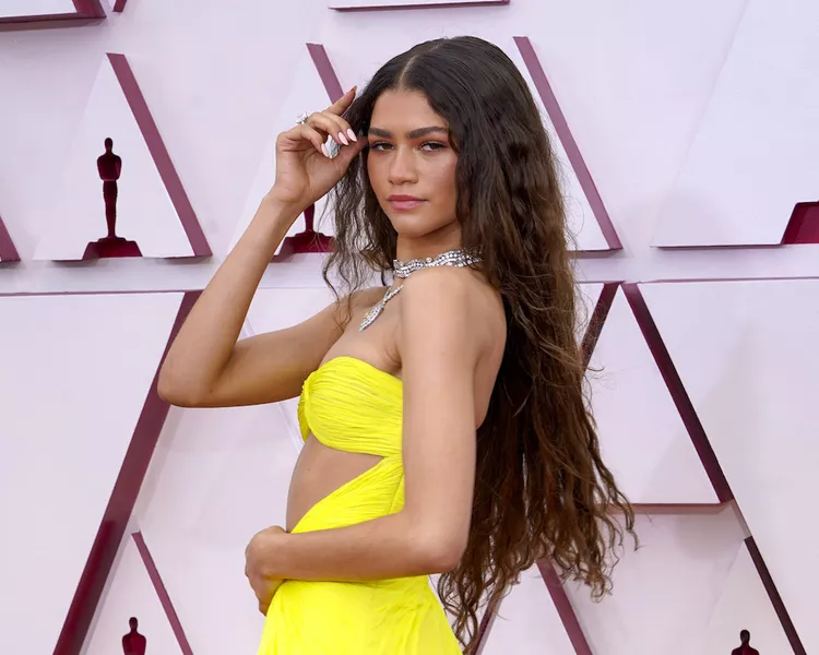 Zendaya wears long mermaid waves and a yellow gown to the 2021 Oscars