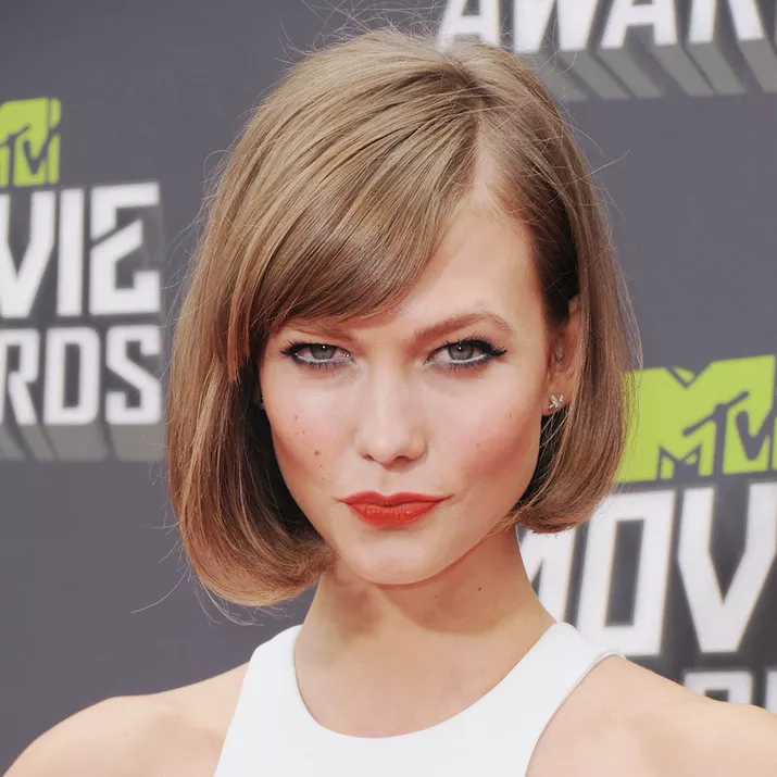 Karlie Kloss wears a blown-out wedge haircut with side-swept bangs
