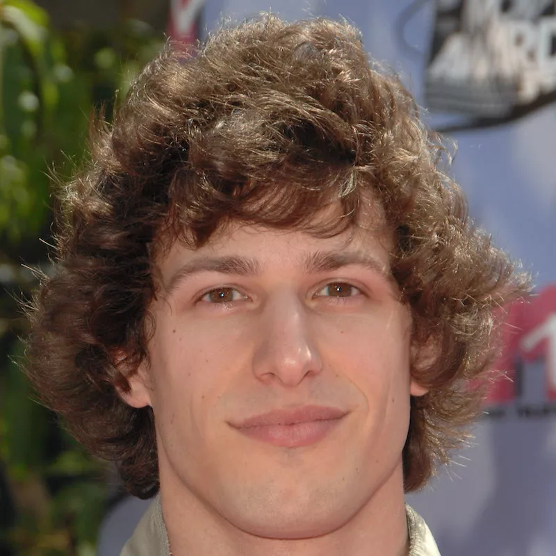 Andy Samberg wears his natural curls in a longer, voluminous style