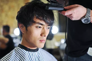 Asian man getting a hair cut