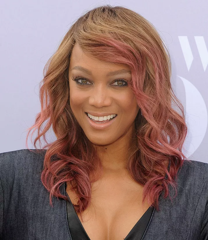 Tyra Banks wavy mid-length hair with pink highlights