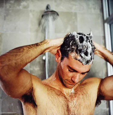 man washing his hair in the shower