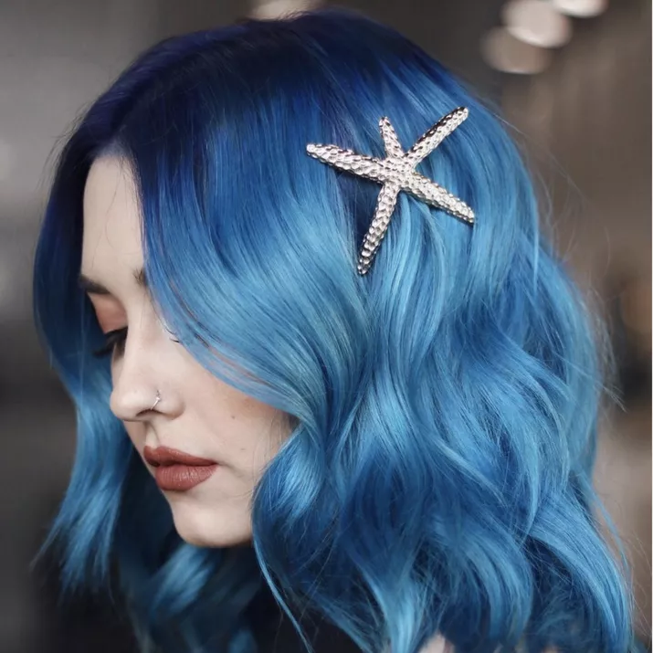 Dark to light curled blue ombre hairstyle with starfish clip