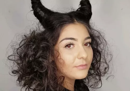 Woman with Maleficent-inspired curly hairstyle with horns