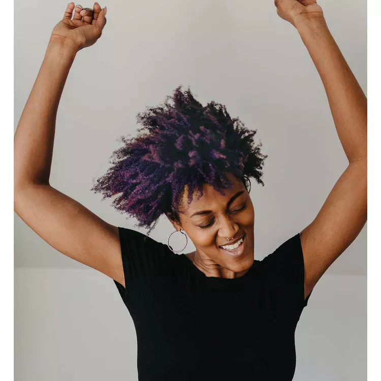 person with purple hair dancing happy