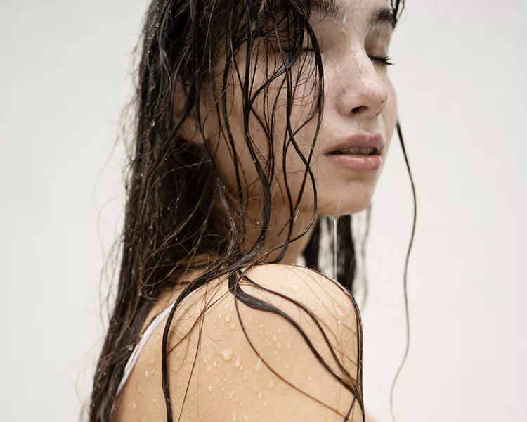 Woman with dark, fine hair that is wet