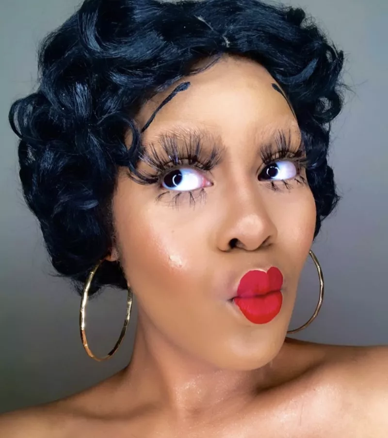 Woman with Betty Boop lashes, lipstick, and short curly wig