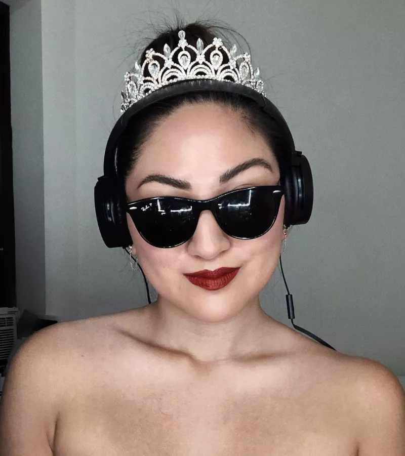 Kristina Rodulfo wears a high bun with tiara and headphones like Mia Thermopolis in The Princess Diaries