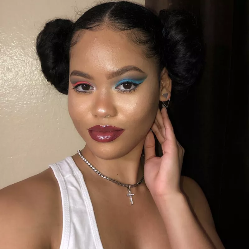 Woman with Princess Leia side buns and one red, one blue eyeshadow