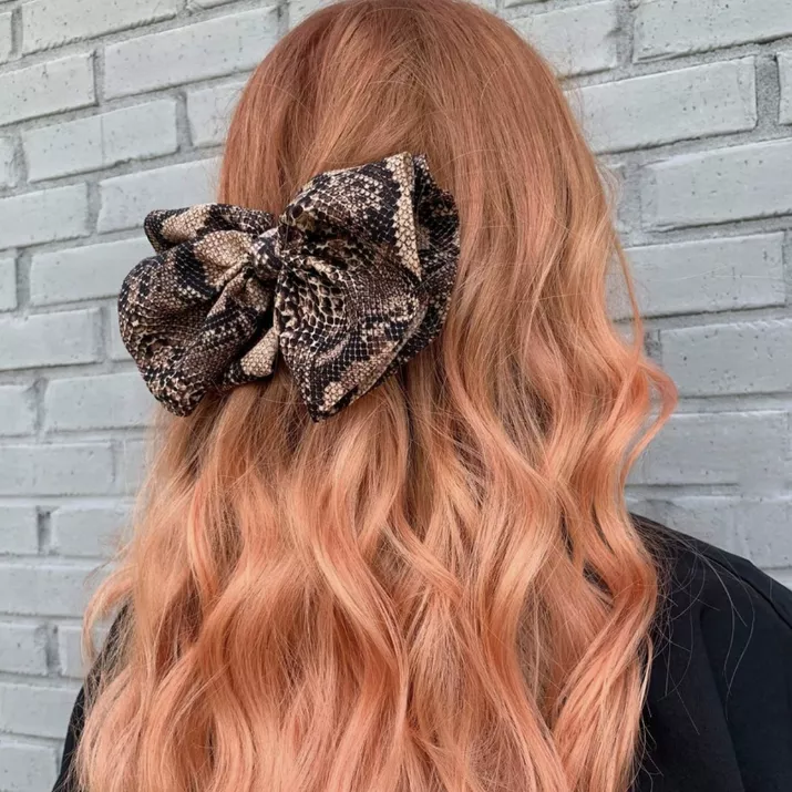 Pink-toned strawberry blonde hair with snakeskin bow