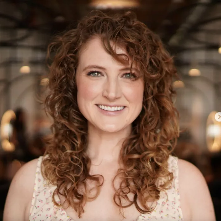 Woman with curly red hair with strawberry blonde highlights