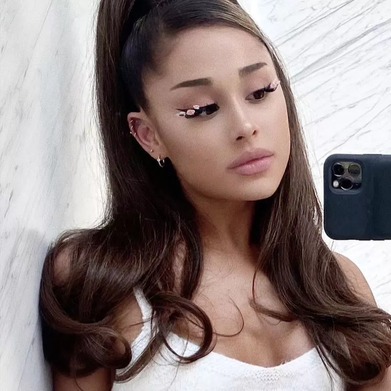 Ariana Grande wears a rose-toned makeup look with floral lashes