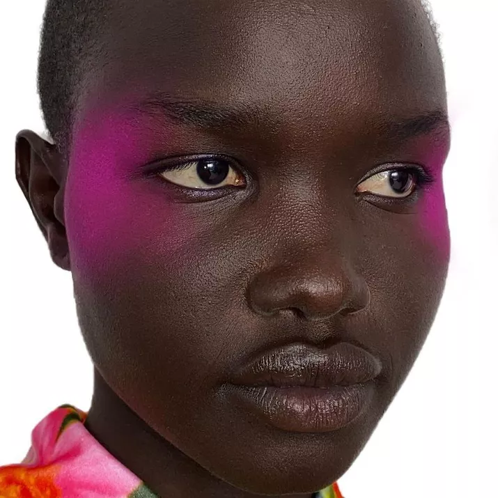 Model with electric pink blush on temples