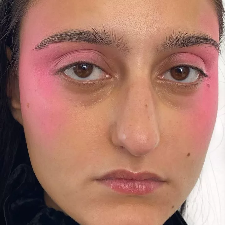 Woman with dramatic carnation pink blush on eyes, temples, and cheeks