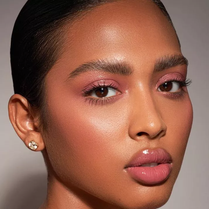 Model with glossy pink eyeshadow and lips and soft pink blush