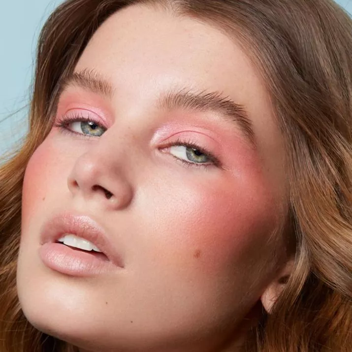 Model wears dramatic pink eyeshadow and blush look