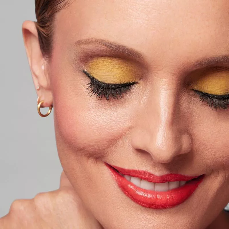 Model wears dandelion yellow eyeshadow with eyeliner and red lipstick