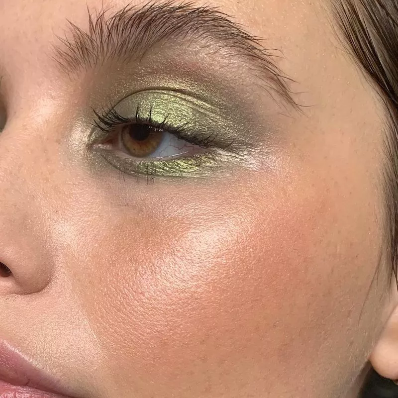 Model with metallic apple green eyeshadow and radiant skin