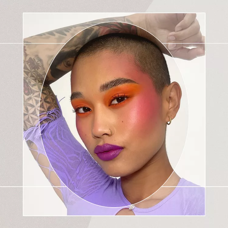 Portrait of AAPI Subject with Buzzcut Wearing Bold Orange Eyeshadow that Blends into Pink Blush Draping and Purple Lipstick