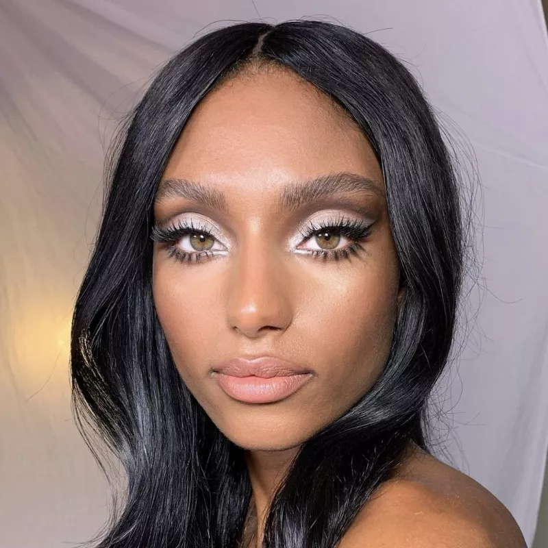 Model wears silver smoky eyeshadow with lashes and nude lipstick