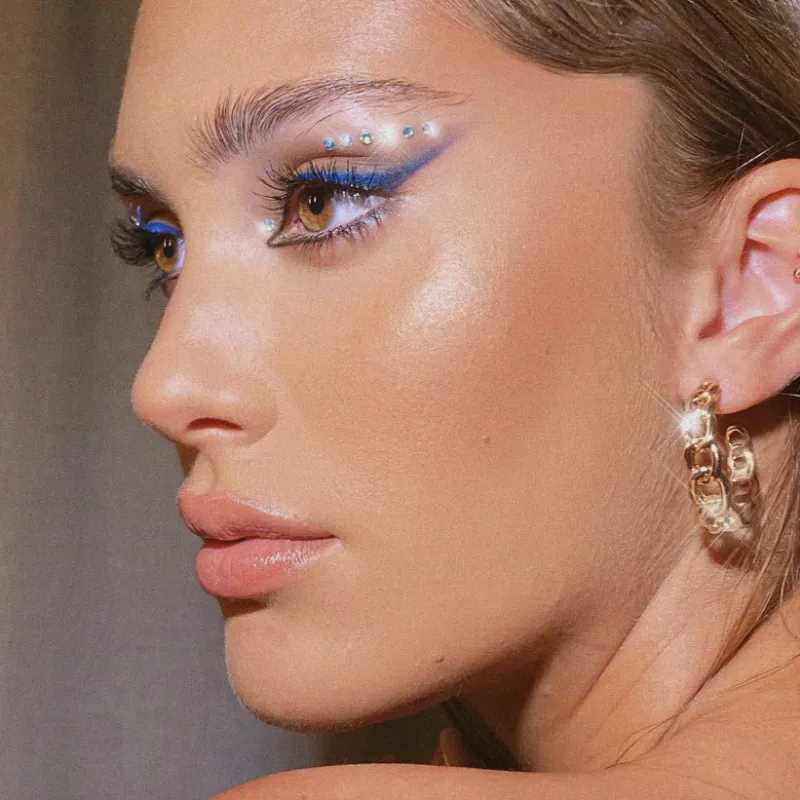 Woman with smoky blue winged eyeliner and blue and white gemstones