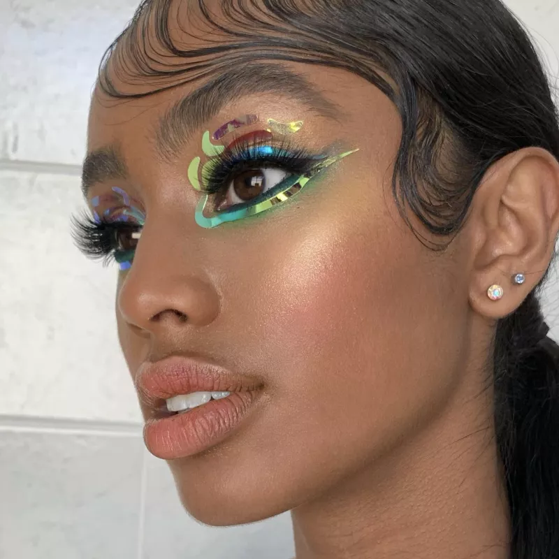 Model with holographic sticker eyeliner and finger wave hair