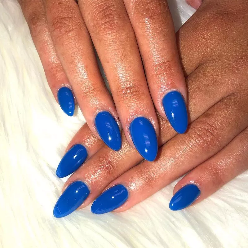 Cobalt blue dip powder nail color on crossed hands