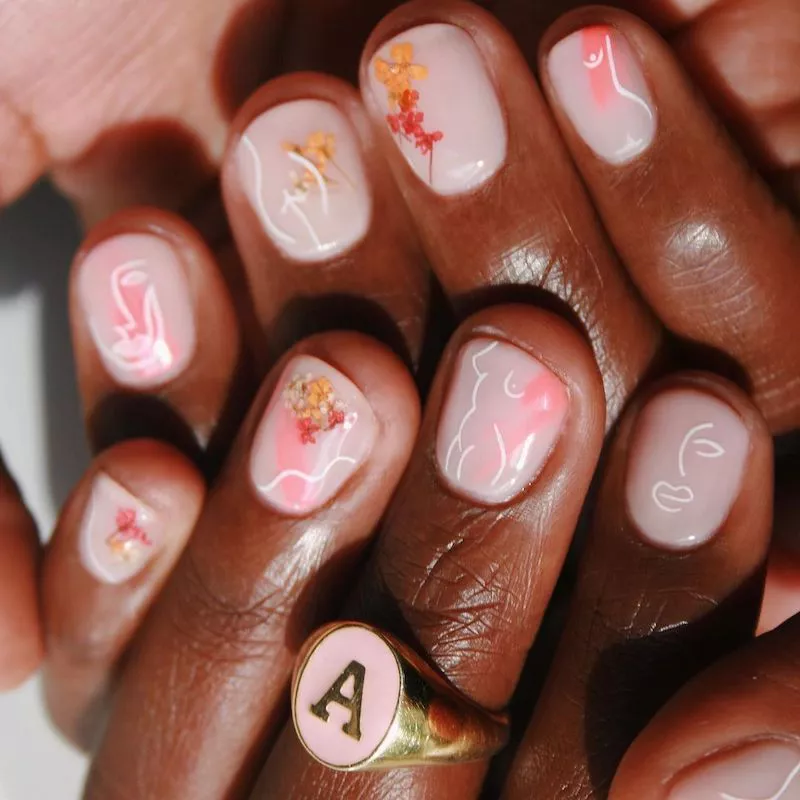 Pale pink nails with abstract face and feminine body outlines