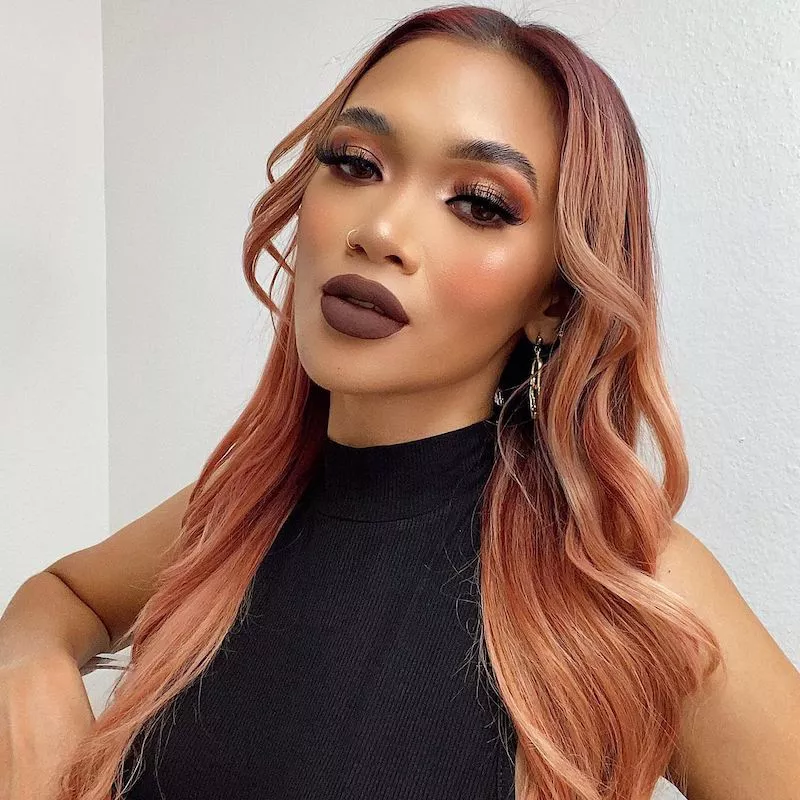 Woman with rose gold hair and eyeshadow look and dark brown lipstick