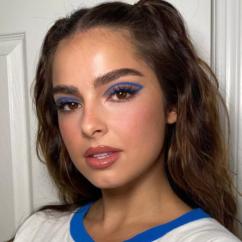 Addison Rae wears blue graphic floating eyeliner and neutral lip gloss