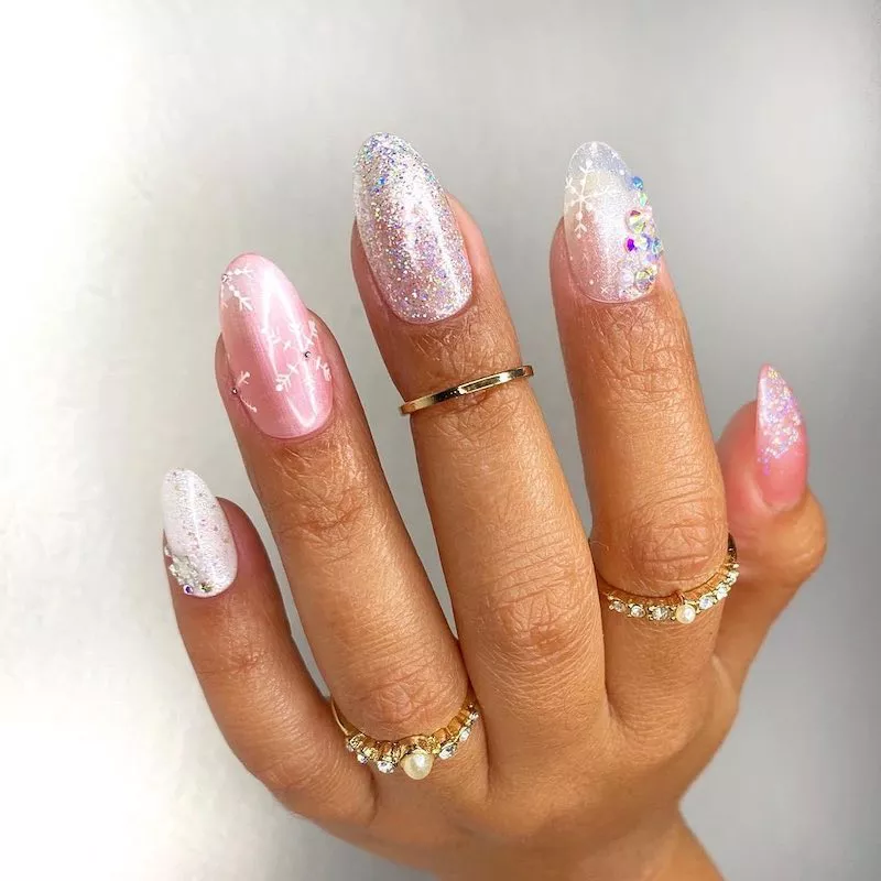 Pink and silver sparkle manicure with varied snowflake designs