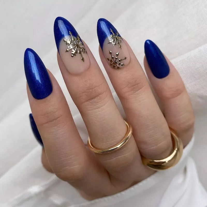 Royal blue manicure with French tip accent nails featuring silver snowflakes