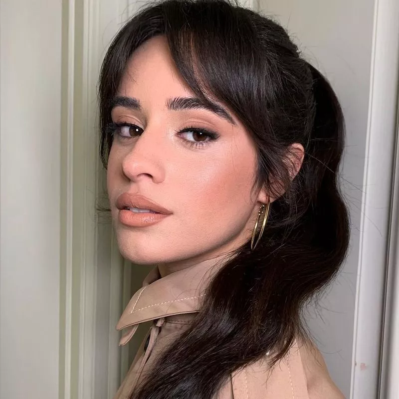 Camila Cabello wears a radiant neutral makeup look and classic ponytail