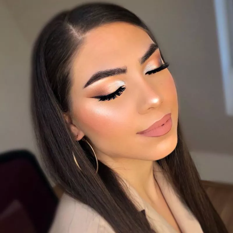 Woman with highlighted skin and soft glam eye makeup