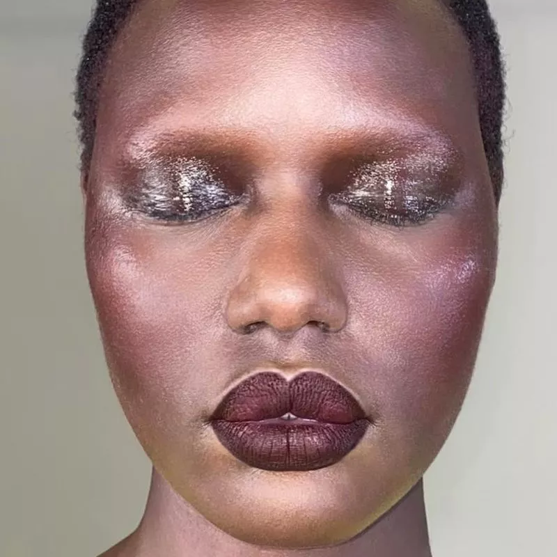 Model with glossy, sparkly eyeshadow and matte burgundy lipstick