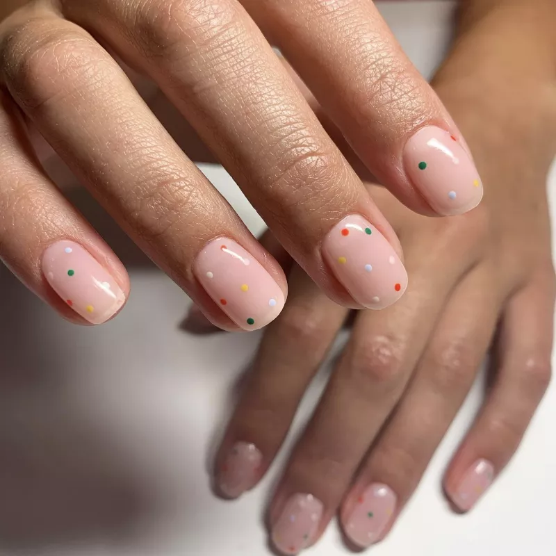 Peachy nude nails with rainbow polka dots