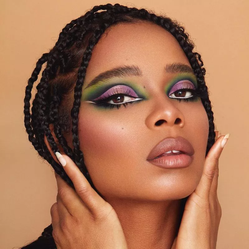 Model with colorful purple and green gradient eyeshadow and black and white graphic floating eyeliner
