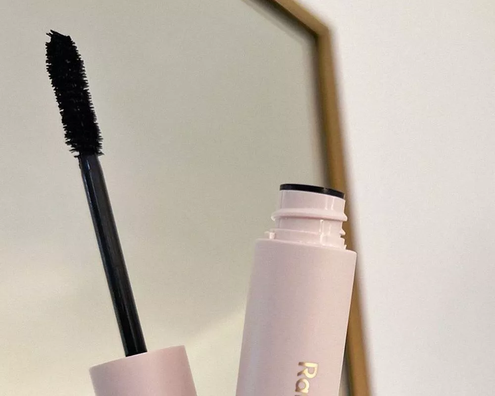 Mascara tube and wand with mirror in background