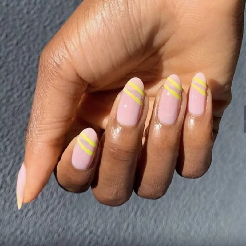 SNS pale pink dip powder manicure with yellow diagonal stripes