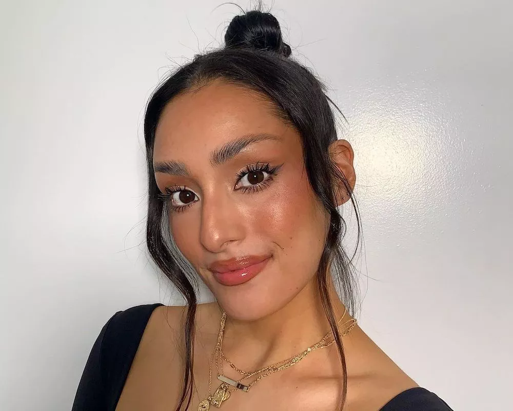 Makeup artist Sophia Vallejos wears a bronzed makeup look with dramatic lashes
