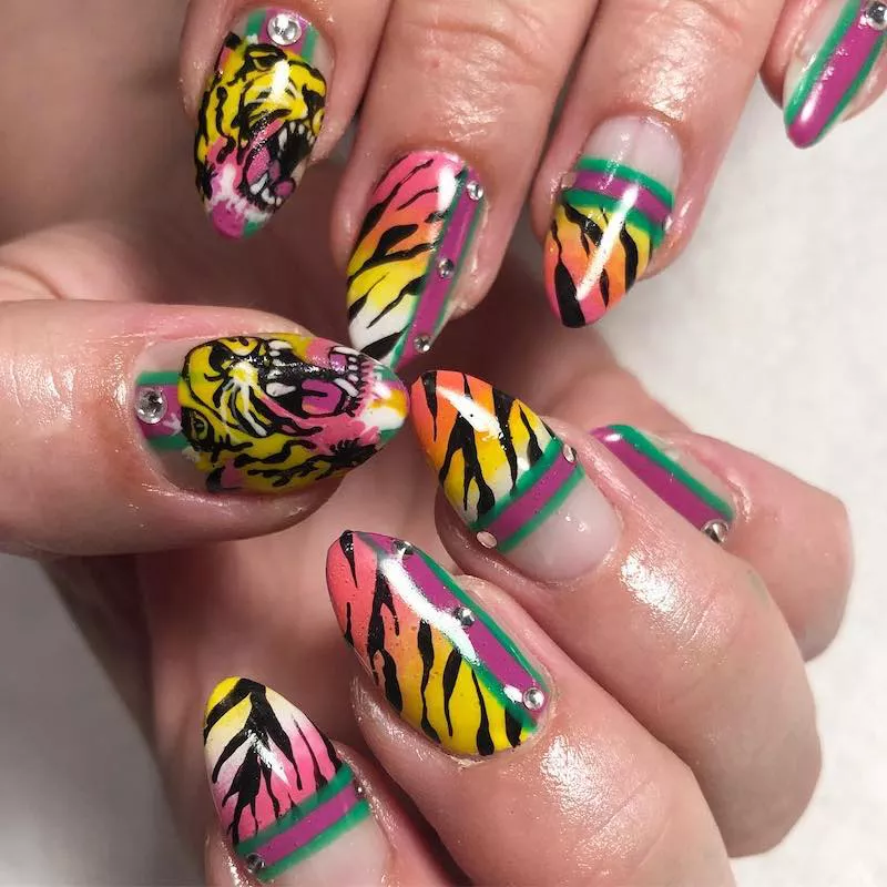 Almond-shaped nails with Gucci stripe and warm-toned tiger design