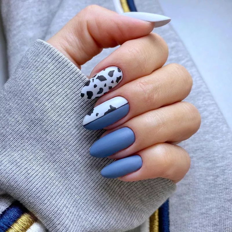 Half-cow print, half-solid blue almond-shaped nails
