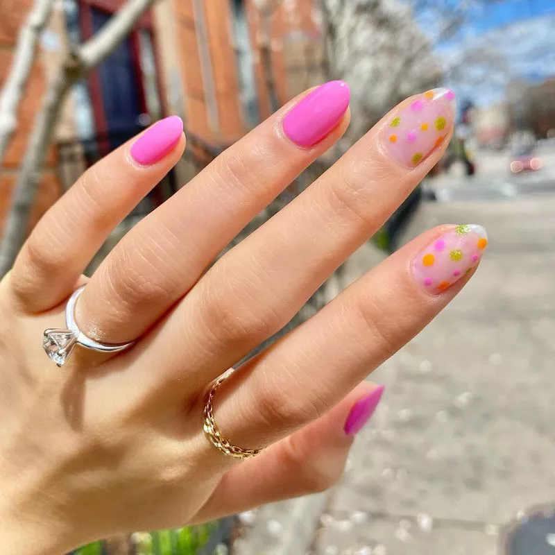 Pink almond manicure with negative space dotted accent nails